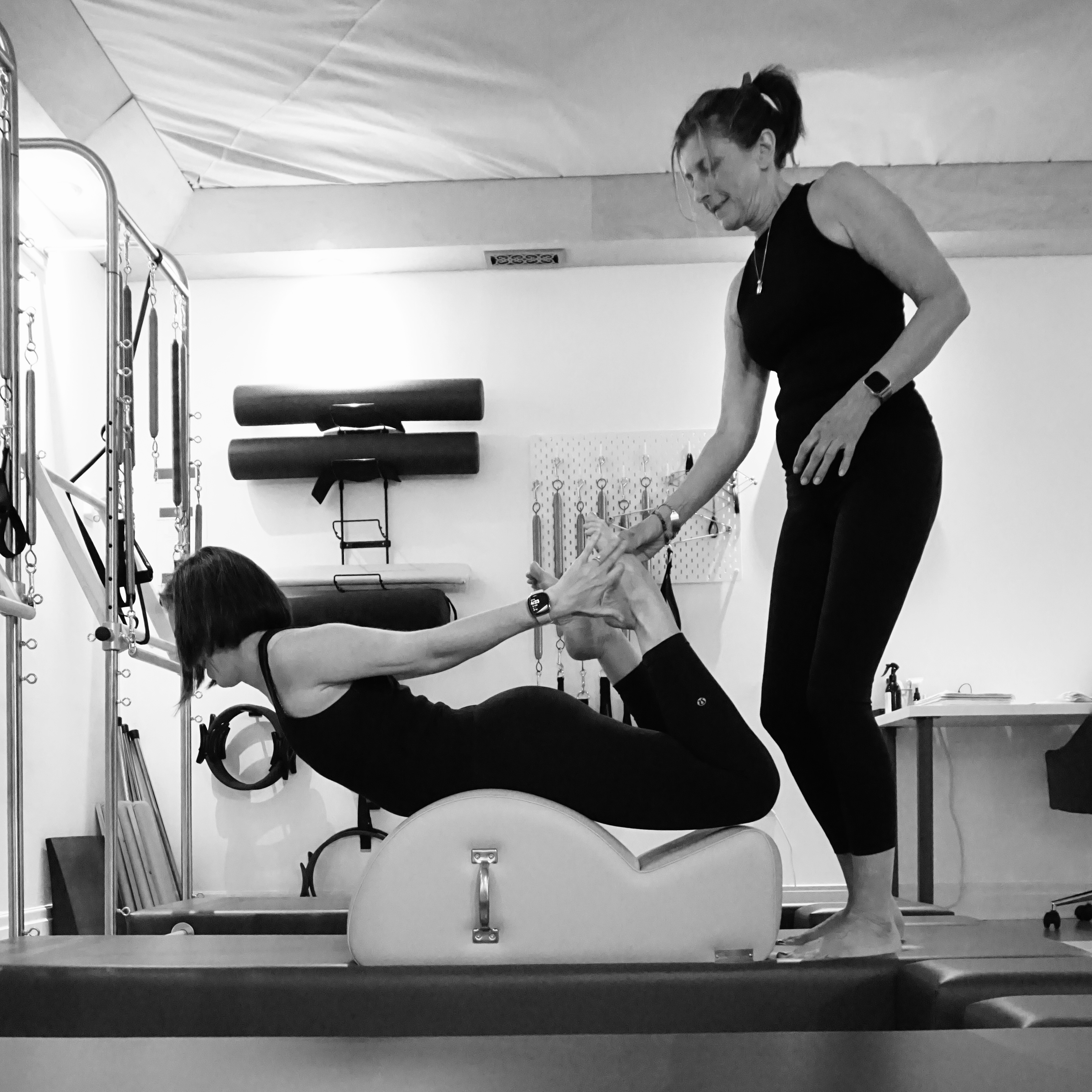 Instructor guiding a Pilates back extension on a spine corrector at Heart of Movement