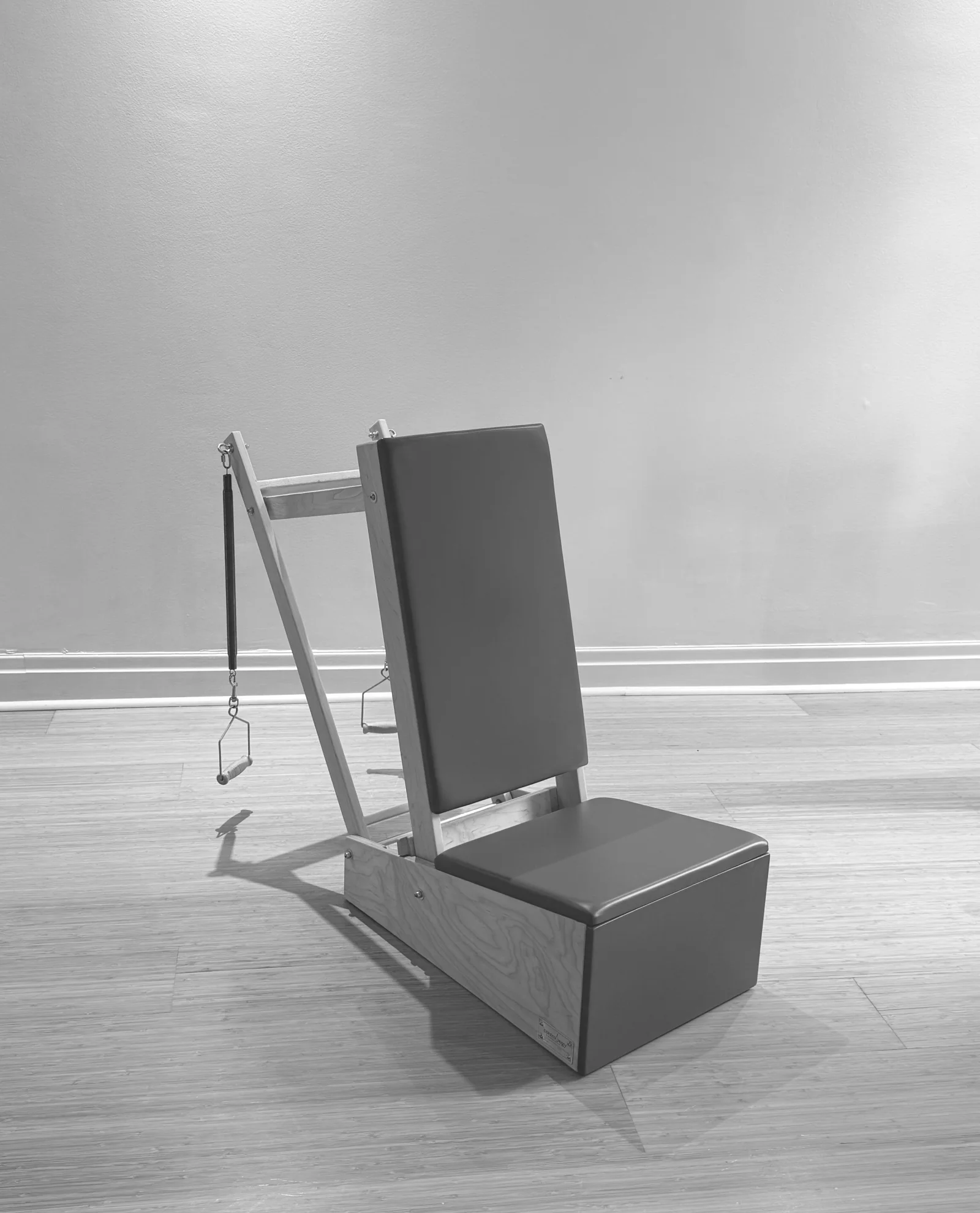 Pilates arm chair with a padded backrest and spring handles