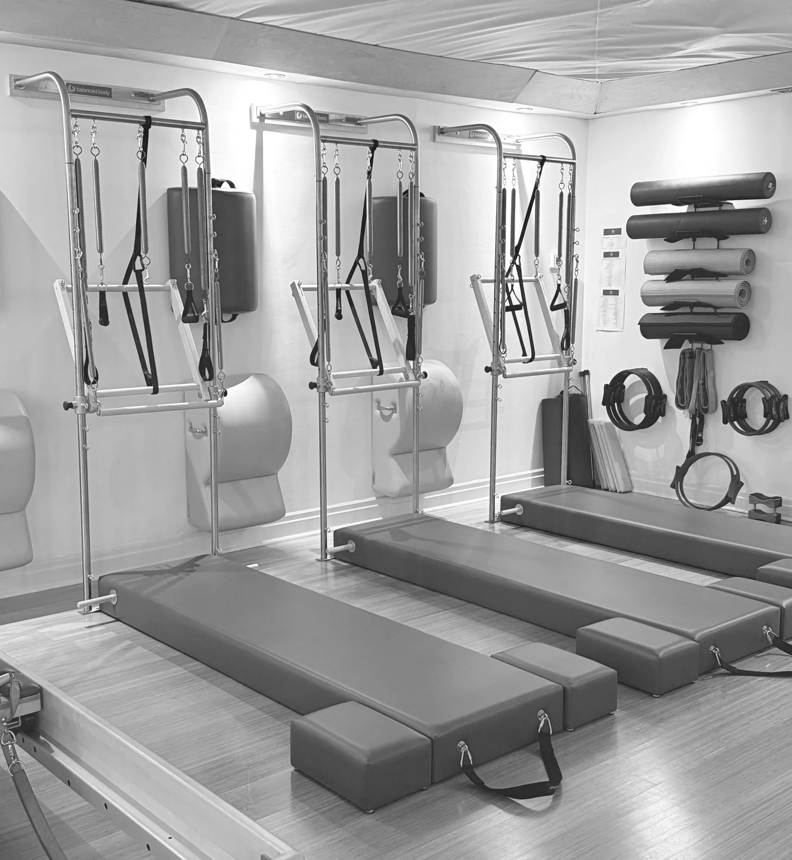 Three Pilates Tower stations with padded mats, springs and push-through bars