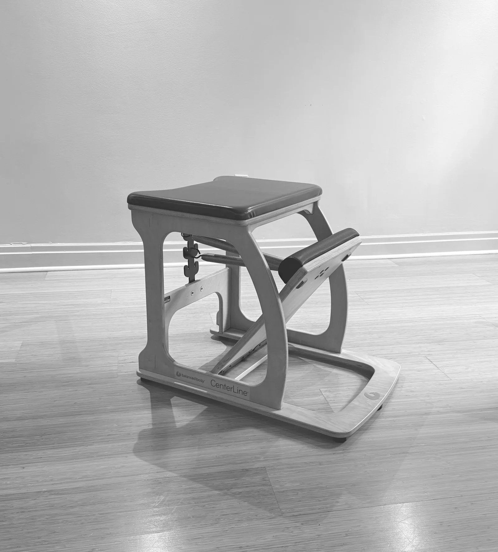 Wooden Pilates Wunda Chair with a padded seat and spring-loaded pedal