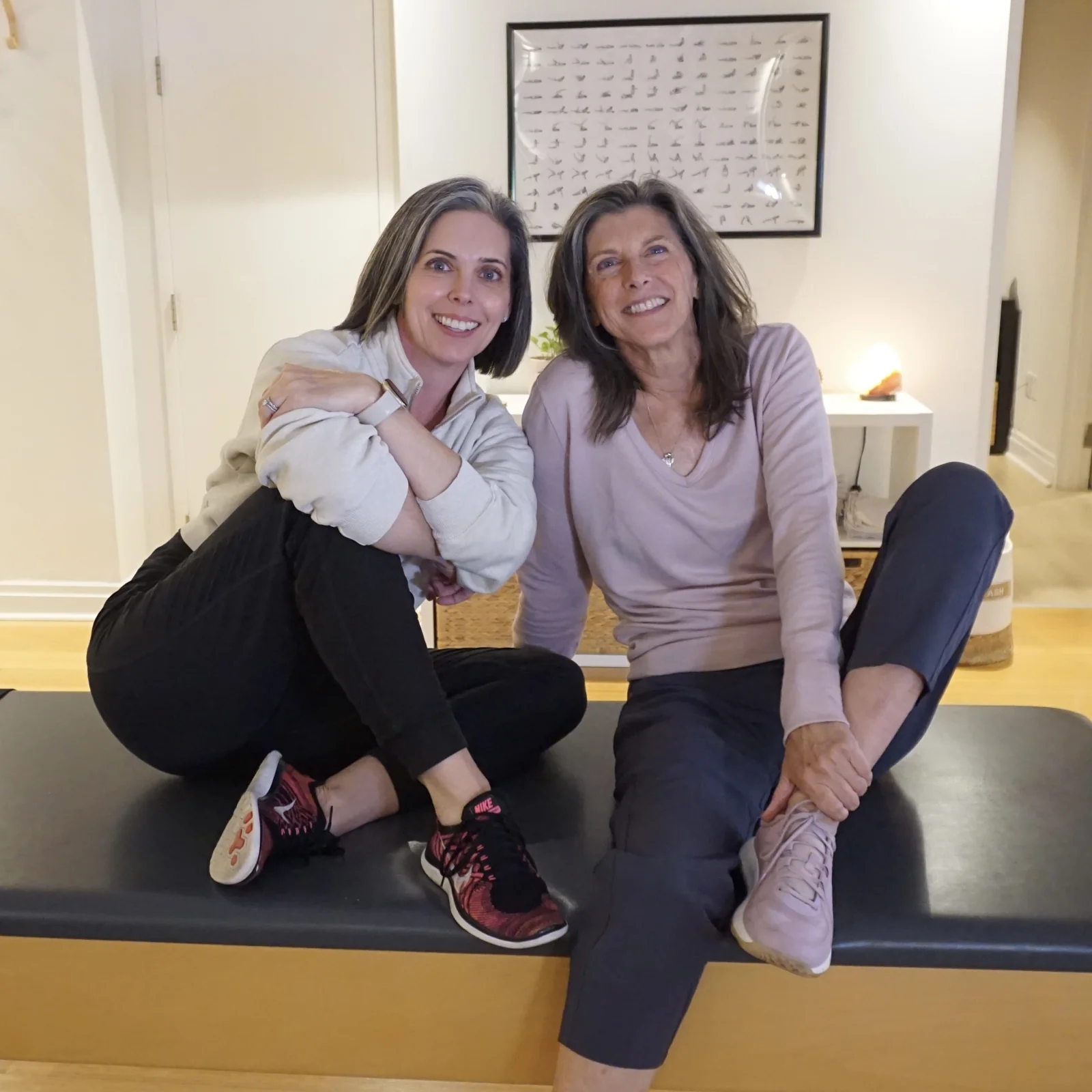 Joanne Decorte and Kim Radovich seated together at Heart of Movement Pilates studio in Oakville