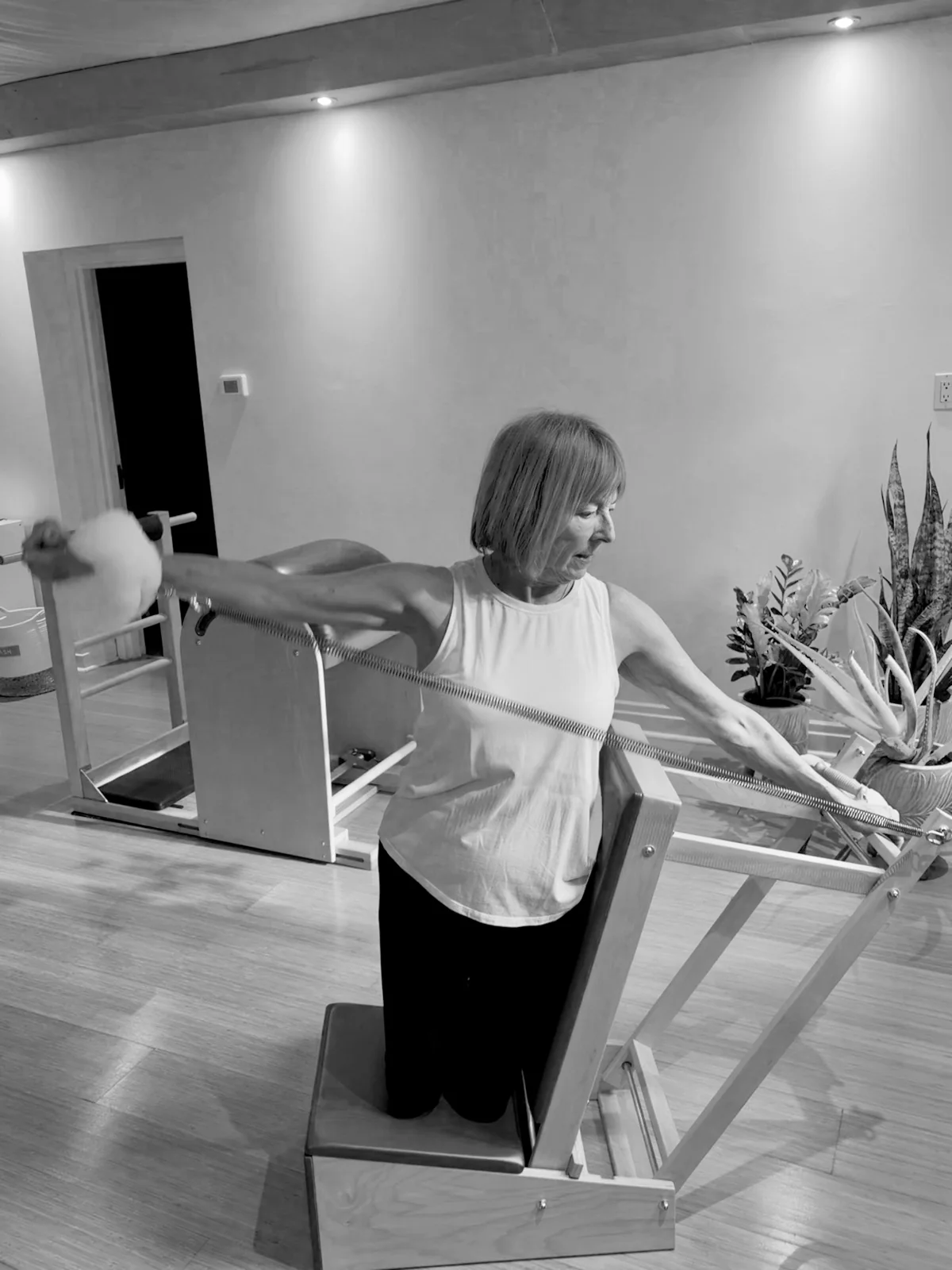 A client extending her arms while practising Classical Pilates on a chair